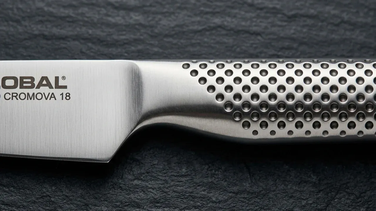 Detalle del mango de acero perforado del cuchillo petty Global GS-89, con su patrón antideslizante de hoyuelos