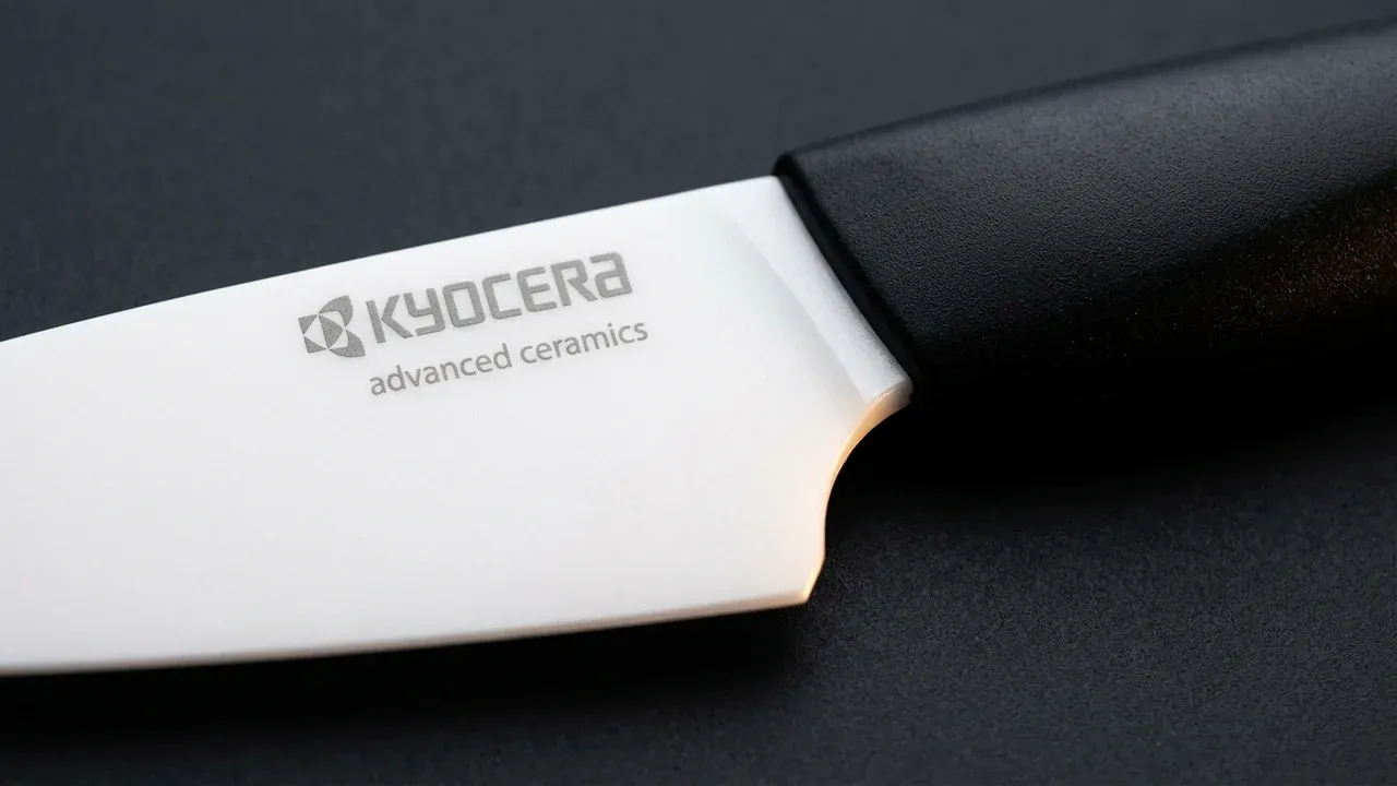 Detalle de la hoja blanca de cerámica de circonio del pelador Kyocera Revolution con el logo KYOCERA advanced ceramics grabado